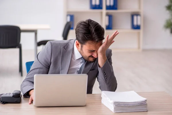 Jeune employé masculin et trop de travail au bureau — Photo