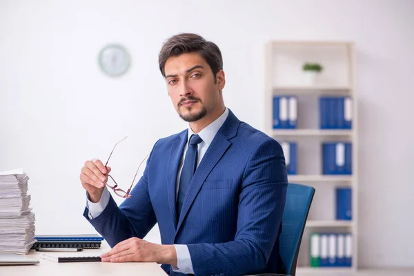 Junge männliche Mitarbeiter und zu viel Arbeit im Büro — Stockfoto