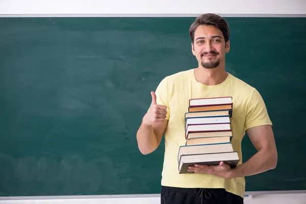Junge männliche Studenten halten viele Bücher in der Hand — Stockfoto