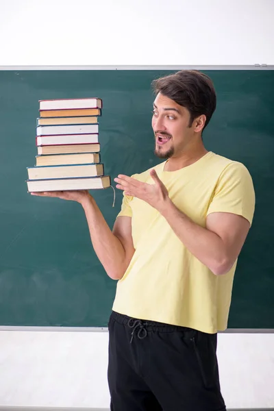 Jonge mannelijke student met veel boeken — Stockfoto