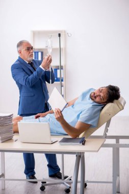 Genç bir erkek işçi iş yerinde kendini kötü hissediyor.