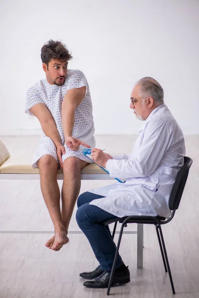 Anciano médico psiquiatra examinando joven paciente masculino —  Fotos de Stock