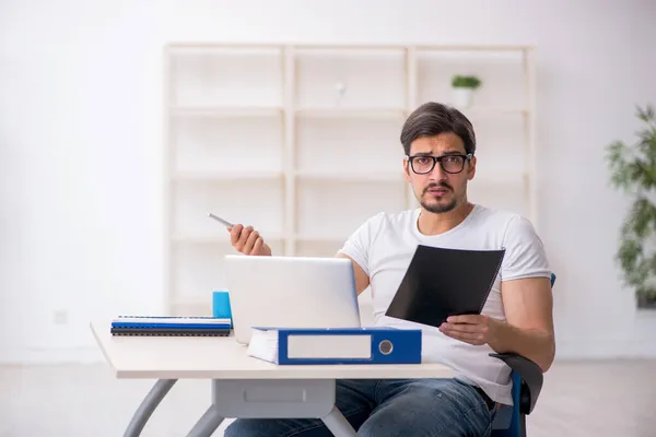 Ung manlig anställd frilansare sitter på kontoret — Stockfoto