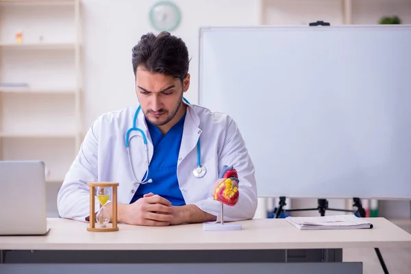 Jovem médico cardiologista no conceito de gerenciamento de tempo — Fotografia de Stock