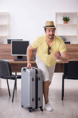 Genç bir erkek işçi iş yerinde geziye hazırlanıyor.