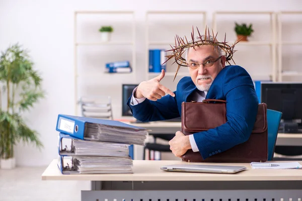 Alter männlicher Angestellter trägt stacheligen Kranz auf dem Kopf — Stockfoto