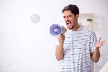 Elinde megafon tutan genç bir hasta.