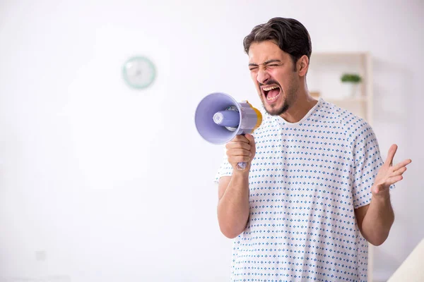 Νεαρός άνδρας ασθενής που κρατάει μεγάφωνο — Φωτογραφία Αρχείου
