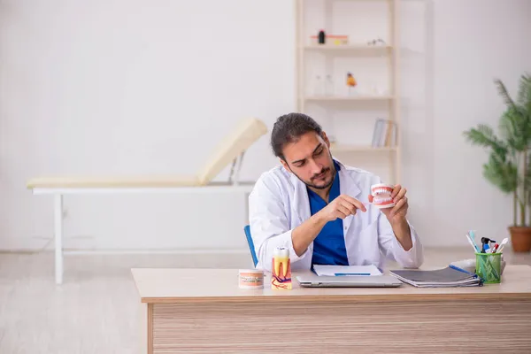 Giovane docente dentista di sesso maschile che lavora in clinica — Foto Stock