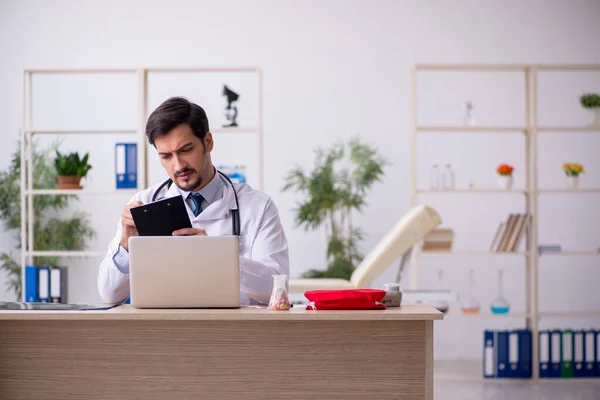 Joven médico masculino que trabaja en la clínica — Foto de Stock