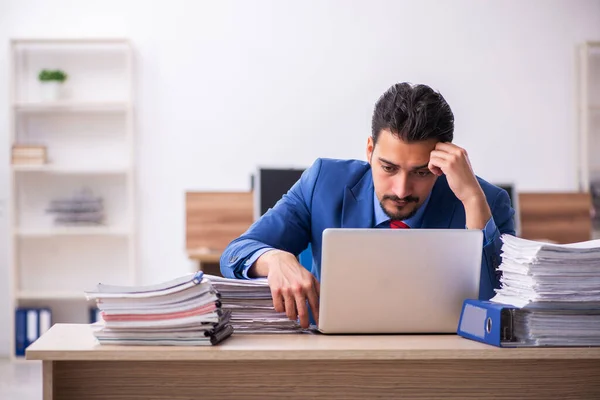 Joven empleado descontento con el trabajo excesivo en el lugar de trabajo —  Fotos de Stock