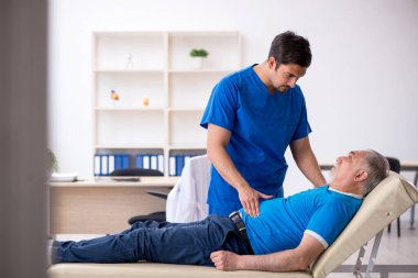 Yaşlı erkek hasta genç erkek doktoru ziyaret ediyor.