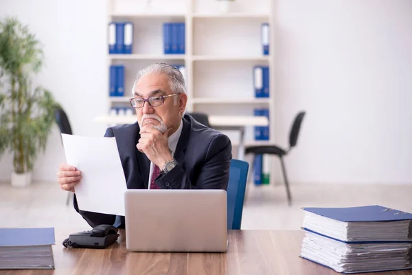 Old male employee and too much work in the office — Stock Photo, Image