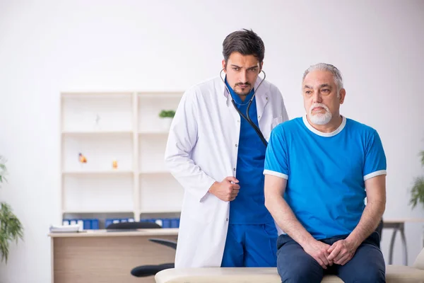 Yaşlı erkek hasta genç erkek doktoru ziyaret ediyor. — Stok fotoğraf