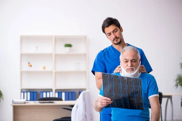 Vecchio paziente maschio in visita giovane medico radiologo maschile — Foto Stock