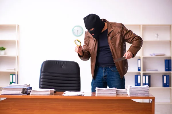 Mladý muž v balaklavě kradoucí informace z kanceláře — Stock fotografie