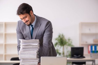 Ofisteki aşırı işten memnun olmayan genç bir erkek işçi.