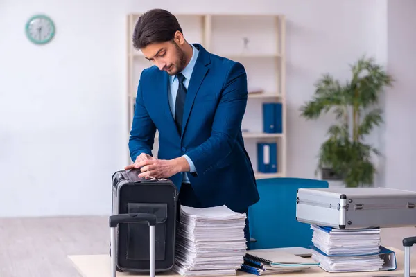 Young male employee preparing for business trip at workplace — Stock Photo, Image