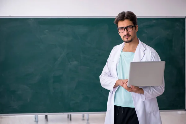 Jonge mannelijke chemicus voor schoolbord — Stockfoto