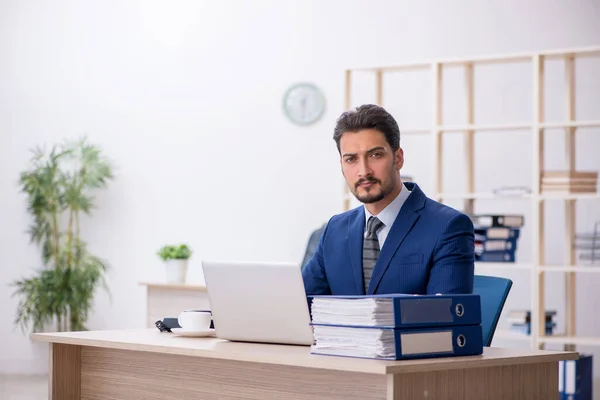 Mladý pohledný zaměstnanec pracující v kanceláři — Stock fotografie