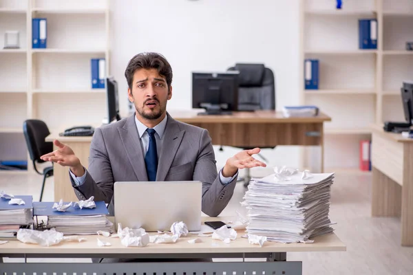 Joven empleado masculino y demasiado trabajo en la oficina — Foto de Stock