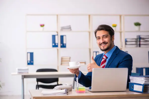 Jonge mannelijke werknemer die koffie drinkt tijdens de pauze — Stockfoto