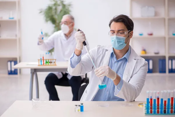 Deux chimistes masculins travaillant au laboratoire pendant la pandémie — Photo