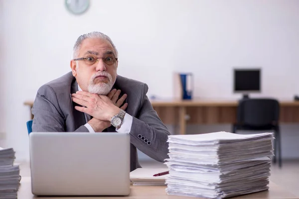 Vecchio dipendente maschio infelice con il lavoro eccessivo in ufficio — Foto Stock