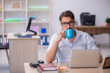 Molada kahve içen genç bir erkek.