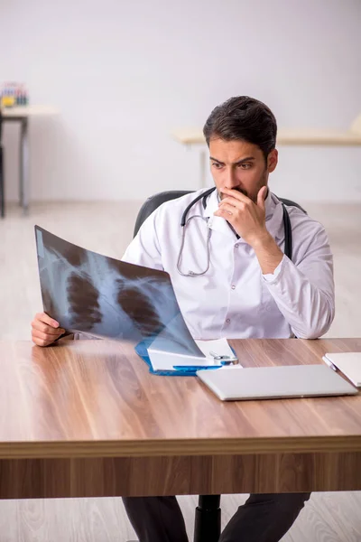 Ung manlig läkare radiolog sitter på kliniken — Stockfoto