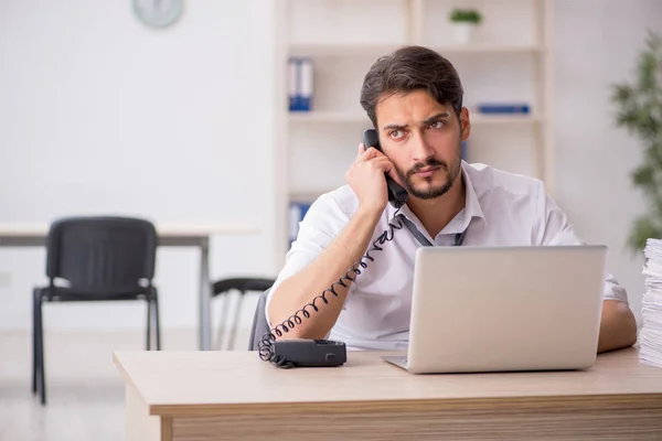 Jeune employé masculin et trop de travail au bureau — Photo