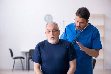 Yaşlı adam genç erkek doktoru ziyaret ediyor.