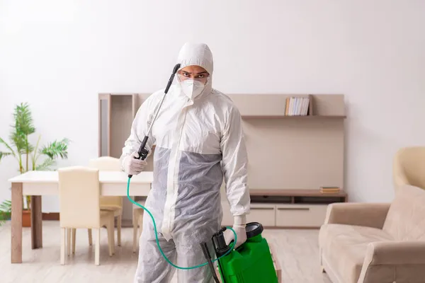 Joven contratista masculino haciendo control de plagas en casa — Foto de Stock