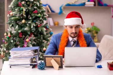 Genç işadamı Noel arifesinde evden çalışıyor.