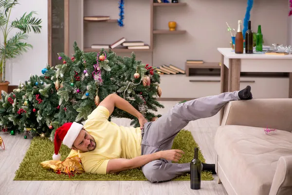 Ung man städa lägenheten efter julfest — Stockfoto