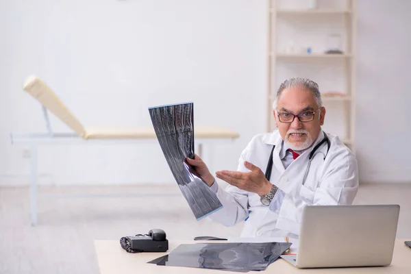 Klinikte çalışan yaşlı bir erkek radyolog. — Stok fotoğraf