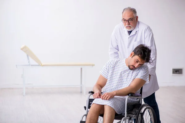 Vecchio medico psichiatra maschio visita giovane paziente disabile — Foto Stock