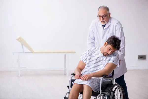 Old male doctor psychiatrist examining young disabled patient