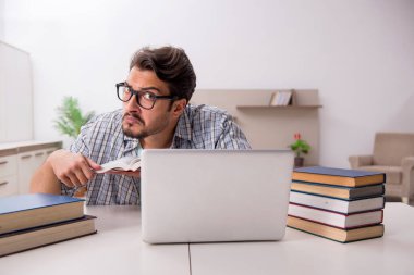 Evde sınava hazırlanan genç bir erkek öğrenci.