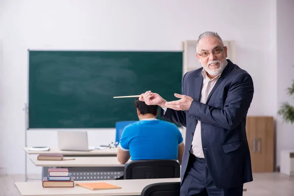 Viejo profesor y joven estudiante delante de la pizarra — Foto de Stock