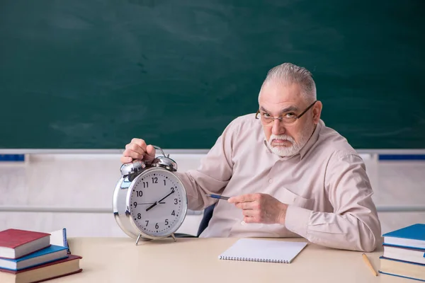 Oude mannelijke leraar in time management concept — Stockfoto