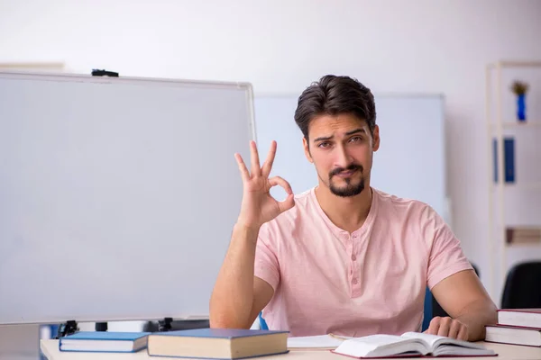 Jovem estudante se preparando para exames em sala de aula — Fotografia de Stock