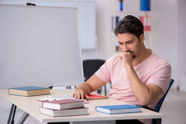 Giovane studente maschio che si prepara per gli esami in classe — Foto Stock