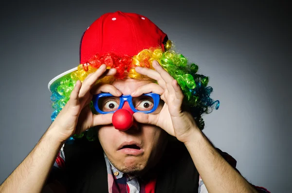 Grappige clown tegen de donkere achtergrond — Stockfoto