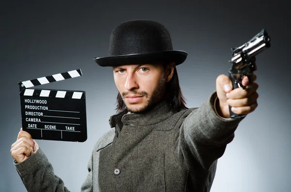 Man with gun and movie clapboard — Stock Photo, Image