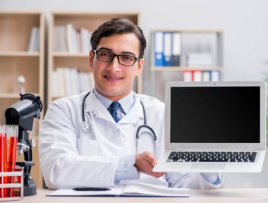 Dizüstü bilgisayarı olan genç bir doktor.