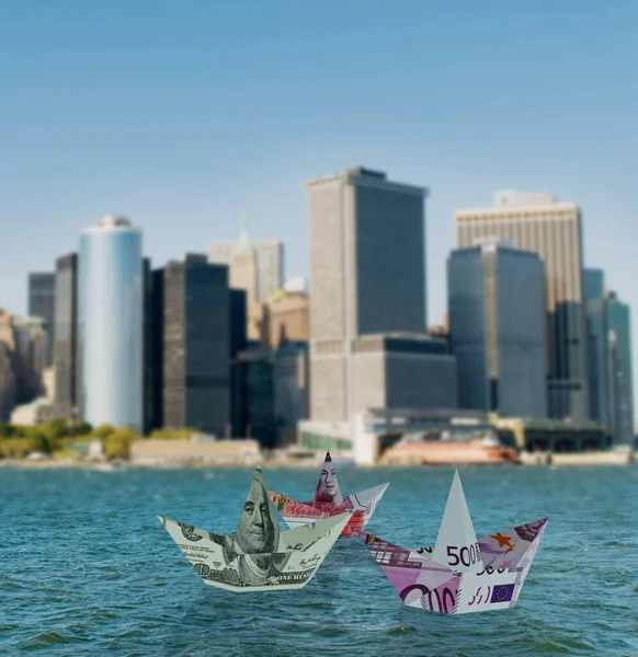 Euro and dollar boats against cityscape — Stock Photo, Image
