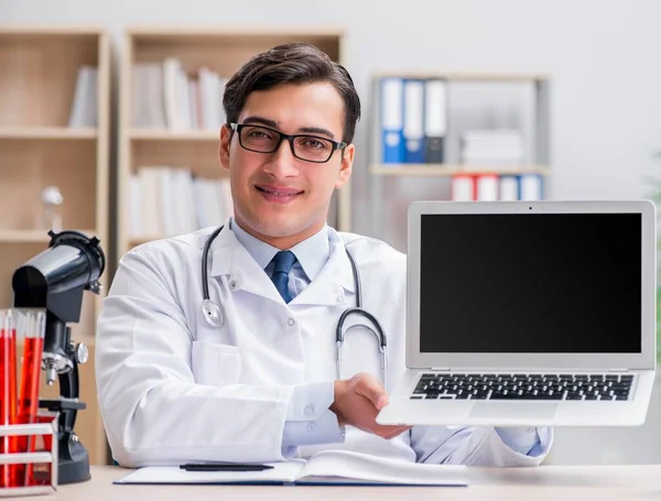 Jeune médecin adulte avec ordinateur portable — Photo