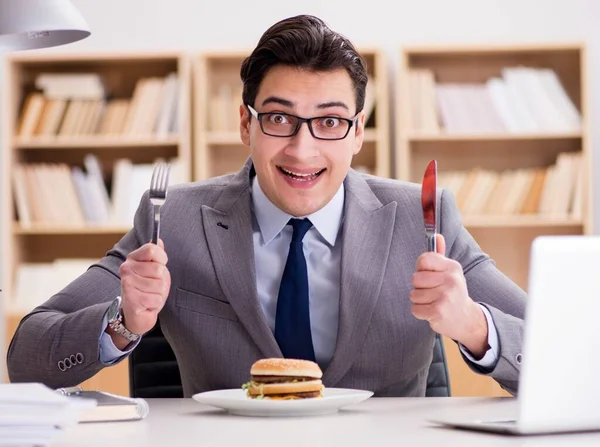 空腹面白いビジネスマンがジャンクフードサンドイッチを食べる — ストック写真
