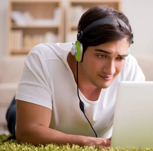 Joven escuchando la música de la computadora portátil —  Fotos de Stock